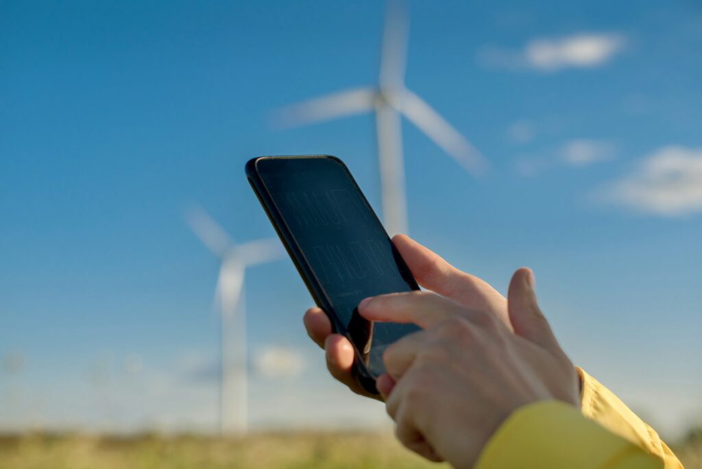 monitoring technical parameters in focus in human hands on a blurred background of wind turbines
